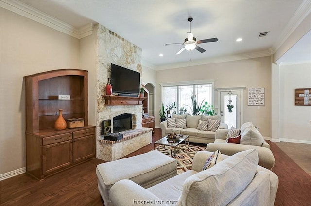 living room featuring a stone fireplace, ornamental molding, and dark wood-type flooring