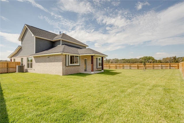 back of property featuring a yard and central AC unit