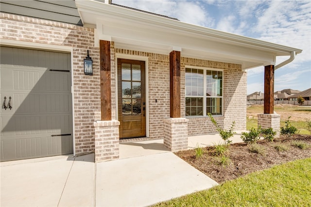 view of exterior entry with covered porch and a garage