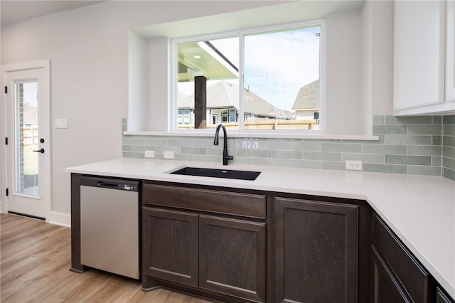 kitchen featuring dishwasher, dark brown cabinets, light wood-type flooring, and sink