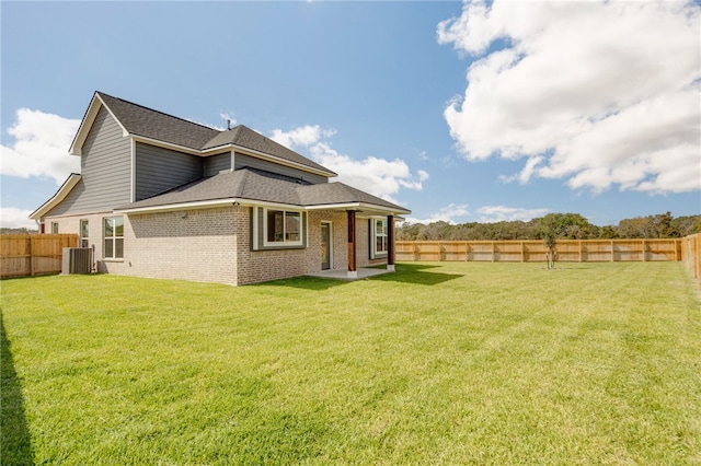 rear view of house with a yard and central AC