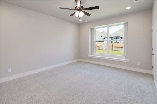 carpeted spare room featuring ceiling fan