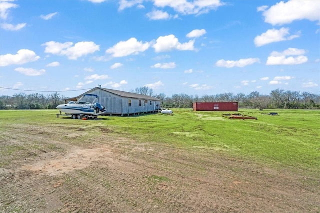 view of yard featuring a rural view, a pole building, and an outdoor structure