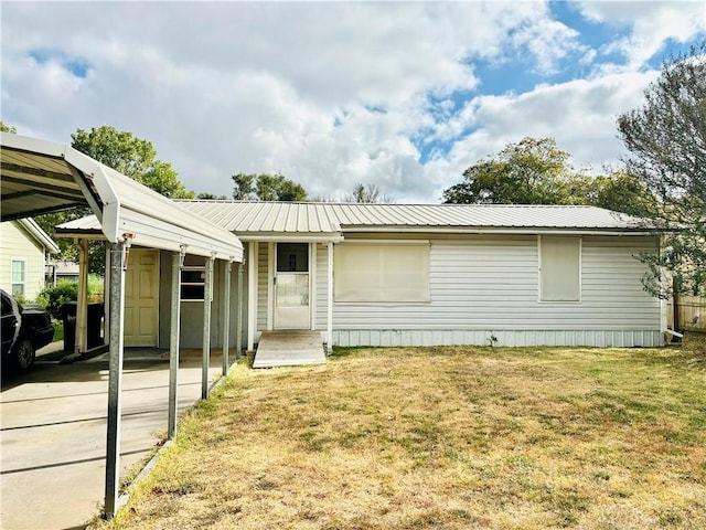 manufactured / mobile home featuring metal roof, a carport, and a front lawn