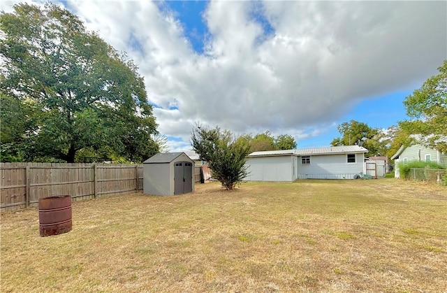 view of yard with a storage unit, an outdoor structure, and a fenced backyard