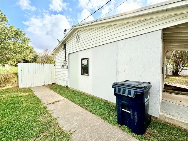 view of side of home featuring stucco siding and fence