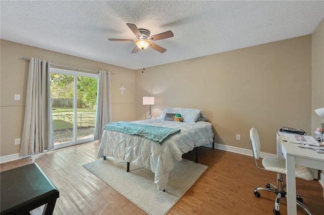 bedroom featuring access to exterior, a textured ceiling, light hardwood / wood-style floors, and ceiling fan