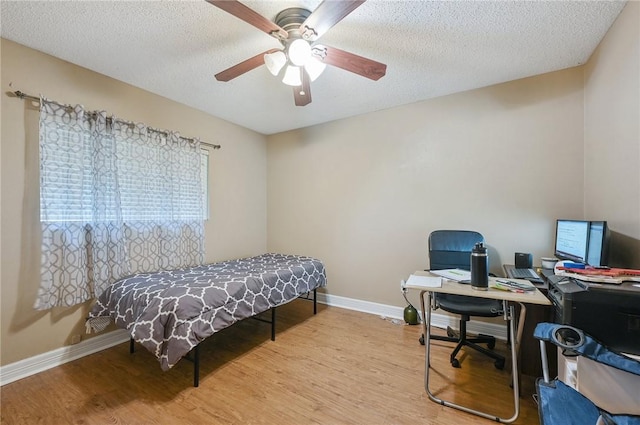 bedroom featuring a textured ceiling, light hardwood / wood-style flooring, and ceiling fan