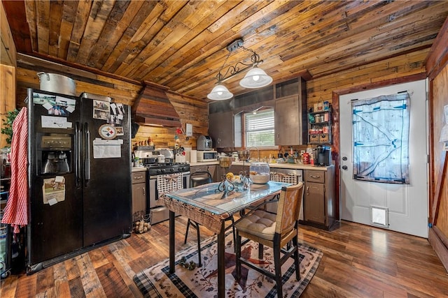 117 S Judge Hailey Dr, Lott, TX 76656 - kitchen with stainless steel range with gas cooktop, wood walls, black fridge with ice dispenser, and white microwave
