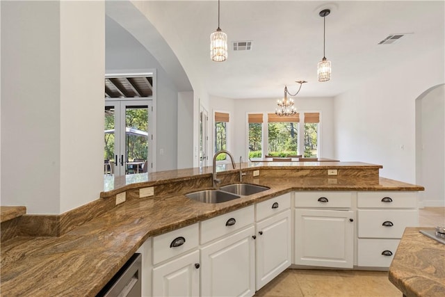 kitchen featuring dark stone countertops, white cabinetry, sink, and plenty of natural light