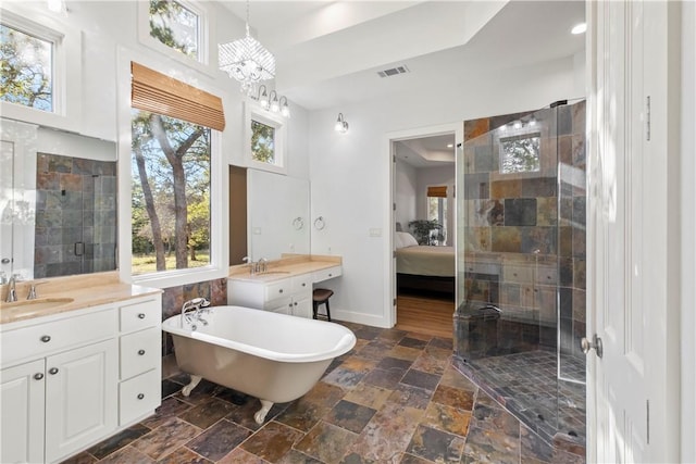 bathroom featuring vanity, independent shower and bath, and a notable chandelier