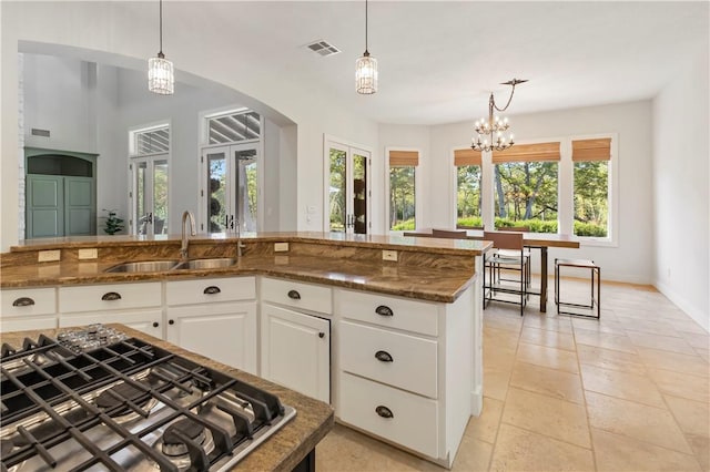 kitchen with white cabinets, pendant lighting, an inviting chandelier, and sink