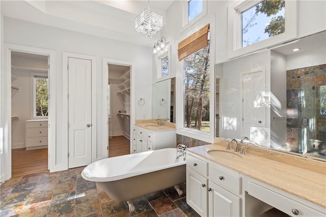 bathroom featuring vanity, a bathtub, plenty of natural light, and a notable chandelier