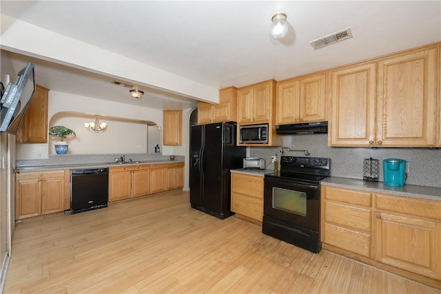 kitchen featuring backsplash, sink, black appliances, light hardwood / wood-style flooring, and a chandelier