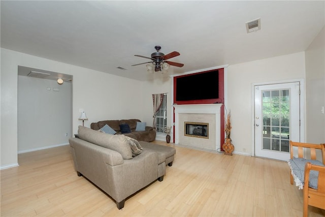 living room with ceiling fan and light hardwood / wood-style flooring