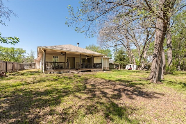 rear view of house featuring a lawn and ceiling fan