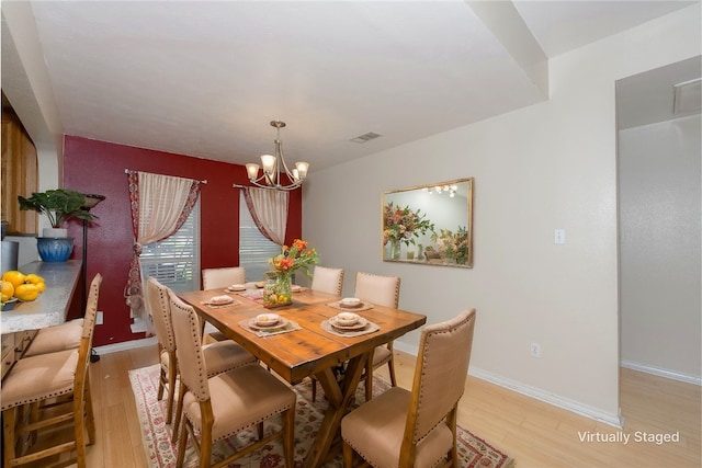 dining area featuring light hardwood / wood-style flooring and an inviting chandelier