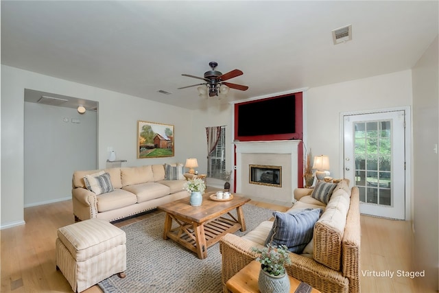 living room with light hardwood / wood-style flooring and ceiling fan