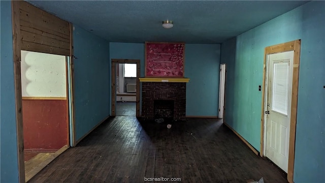 unfurnished living room with dark wood-type flooring and a brick fireplace