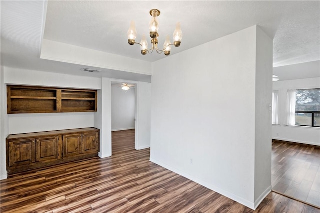 interior space featuring dark hardwood / wood-style floors, a textured ceiling, and a notable chandelier