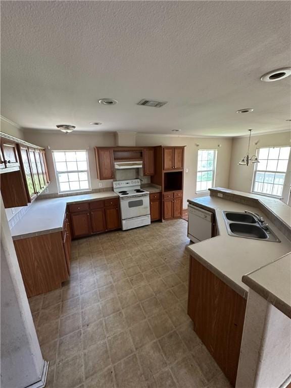 1508 Clark St, Bryan, TX 77808 - kitchen with white appliances, a sink, brown cabinetry, under cabinet range hood, and a textured ceiling
