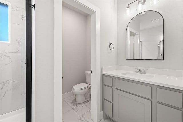 bathroom with vanity, toilet, and a tile shower