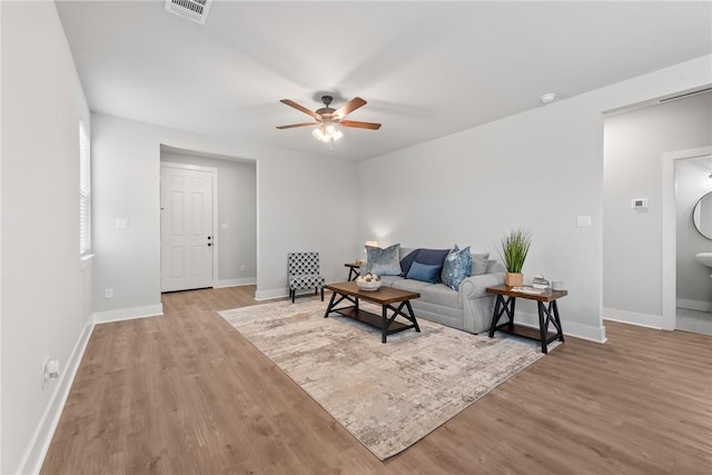 living room with light hardwood / wood-style floors and ceiling fan