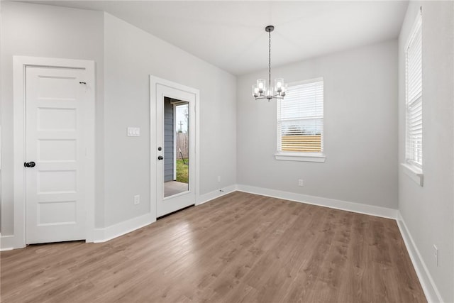 interior space with wood-type flooring and an inviting chandelier