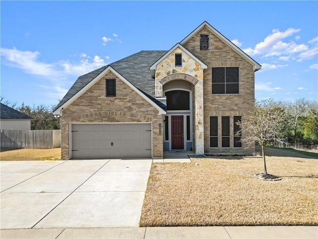 traditional-style house featuring driveway, a garage, fence, and brick siding