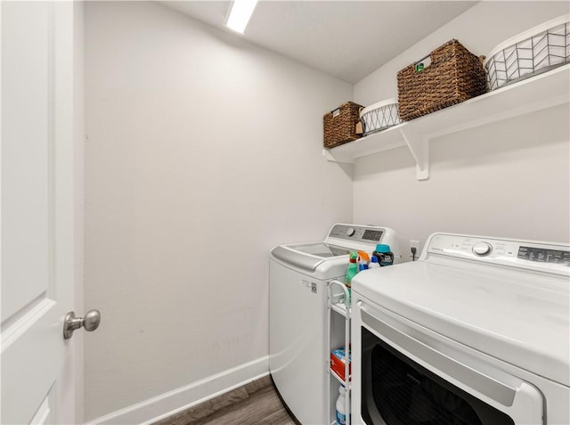 clothes washing area with dark hardwood / wood-style floors and independent washer and dryer