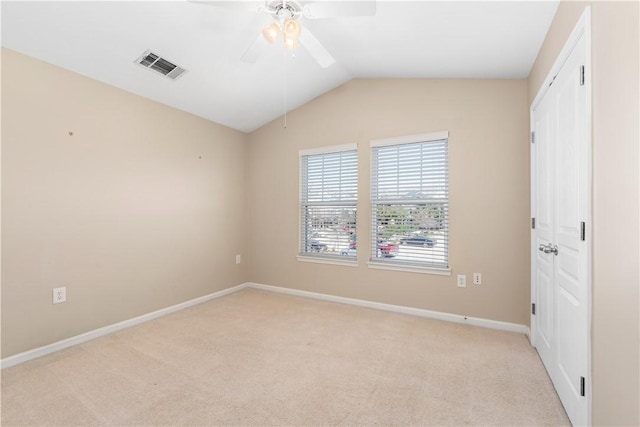 carpeted empty room featuring ceiling fan and vaulted ceiling