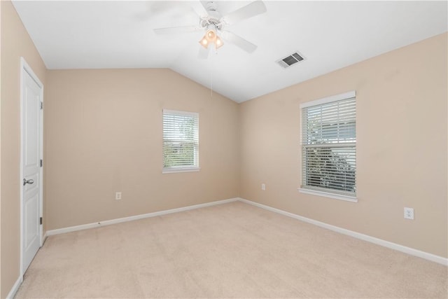 carpeted spare room featuring ceiling fan, plenty of natural light, and vaulted ceiling