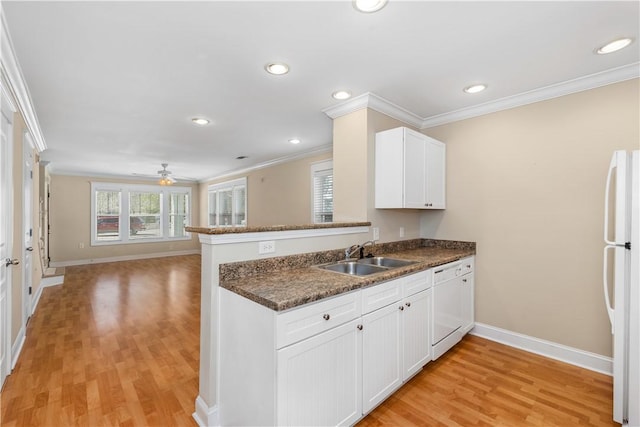 kitchen with kitchen peninsula, white appliances, sink, light hardwood / wood-style flooring, and white cabinets