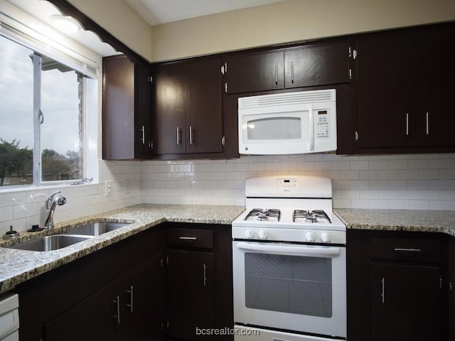 kitchen with white appliances, tasteful backsplash, dark brown cabinetry, and sink