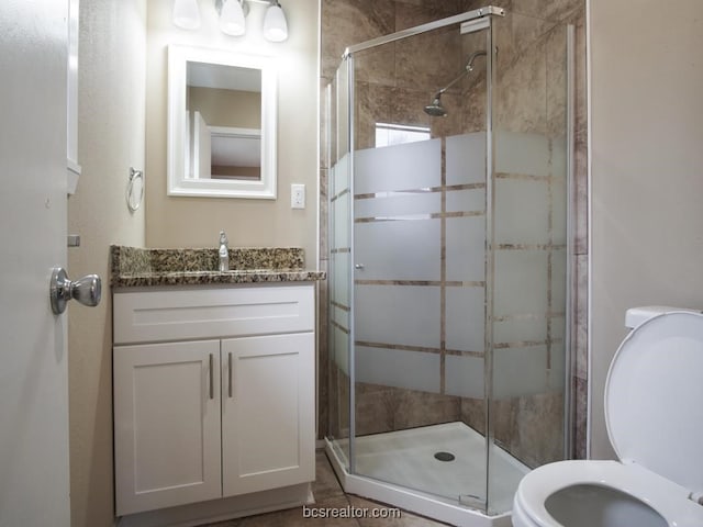 bathroom with toilet, an enclosed shower, and vanity