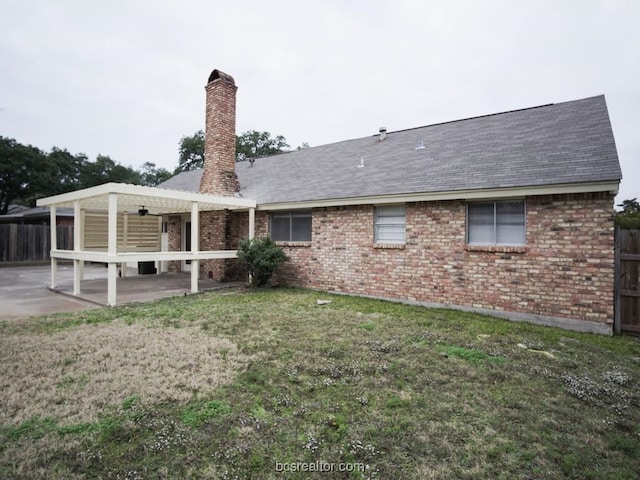 rear view of house featuring a lawn and a patio