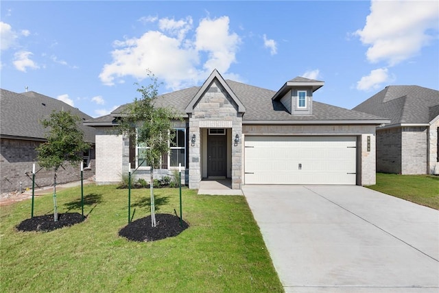 view of front of home featuring a shingled roof, an attached garage, a front yard, stone siding, and driveway