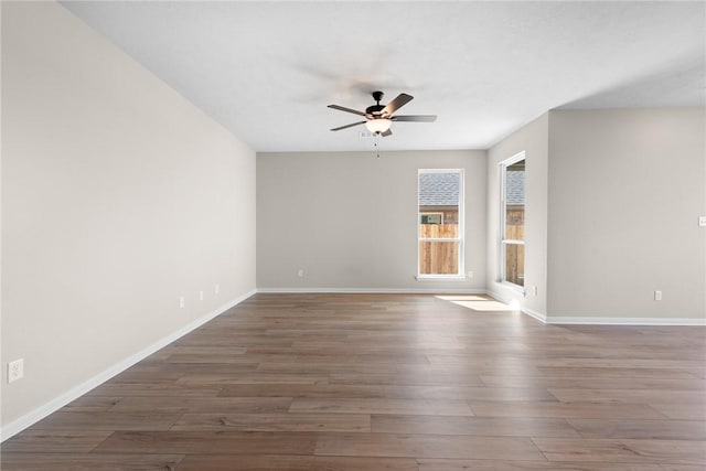 empty room featuring ceiling fan, wood finished floors, and baseboards