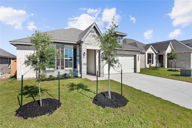 view of front of home featuring an attached garage, driveway, stone siding, and a front yard