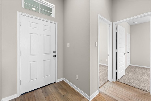 foyer featuring baseboards and wood finished floors