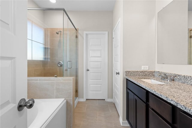 full bathroom with a garden tub, a stall shower, vanity, baseboards, and tile patterned floors