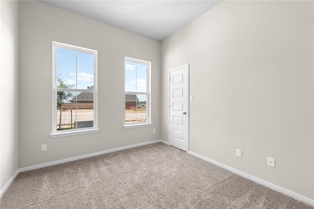 unfurnished room with carpet flooring and baseboards