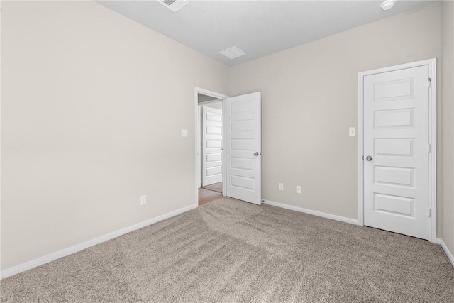 carpeted spare room featuring baseboards