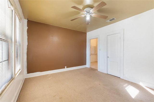 unfurnished bedroom featuring a closet, light colored carpet, and ceiling fan