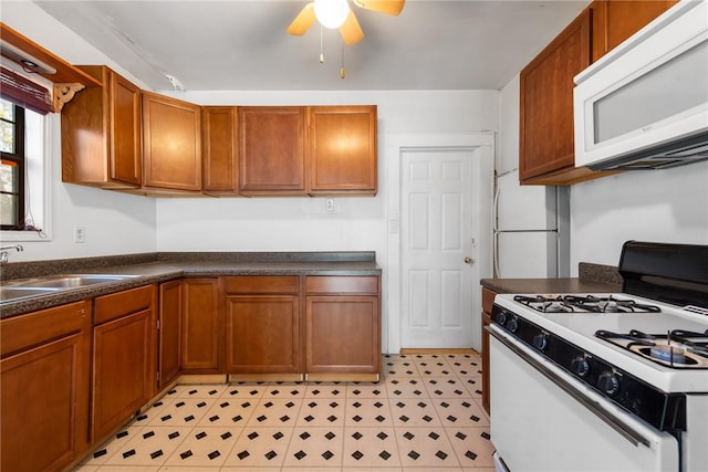 kitchen with ceiling fan, sink, and white appliances