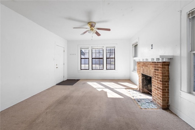 unfurnished living room featuring carpet, ceiling fan, and a brick fireplace