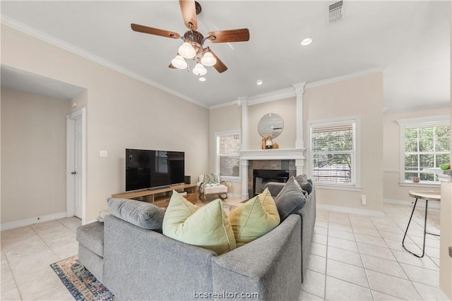 living room with ceiling fan, light tile patterned flooring, crown molding, and a fireplace