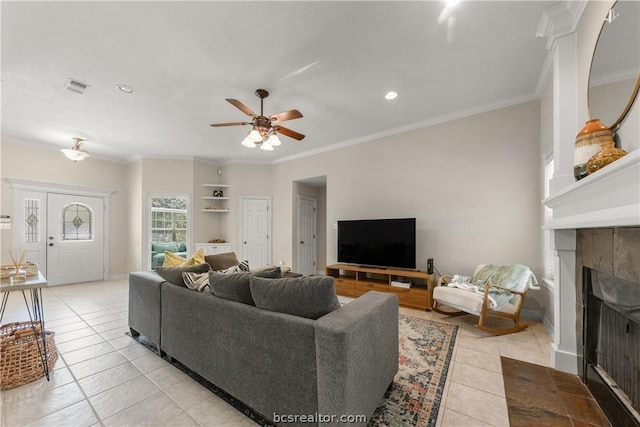 living room featuring a tile fireplace, ceiling fan, ornamental molding, and light tile patterned flooring