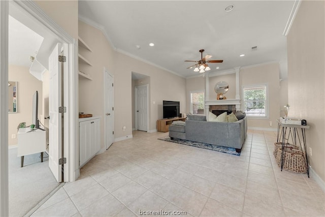 tiled living room with ceiling fan, ornamental molding, and a fireplace