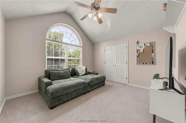 living room with ceiling fan, light colored carpet, and vaulted ceiling